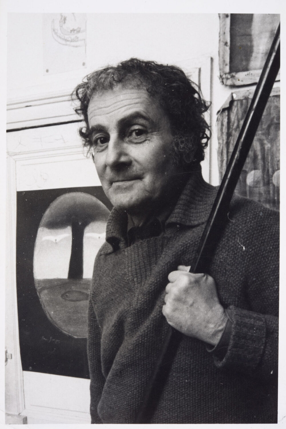 Photo de Georges Arditi dans son atelier de la rue des Martyrs vers 1980 (devant une affiche de son ami André François)